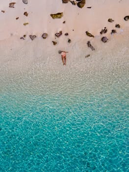 drone view of a woman swimming in the blue turqouse colored ocean of Koh Kradan island in Thailand