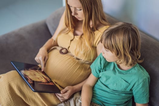 Mom and her son looking on ultrasound image of his unborn baby brother on mothers tablet. Concept of healthcare and family happiness expecting baby.