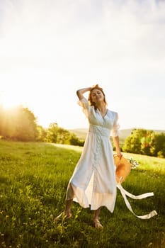 a beautiful woman in a light, summer dress stands in a chamomile field with a basket of flowers in her hands. High quality photo