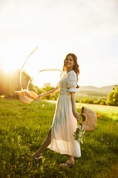 a woman in a white dress with a basket of daisies and a straw hat stands in a field during sunset in a light breeze. High quality photo