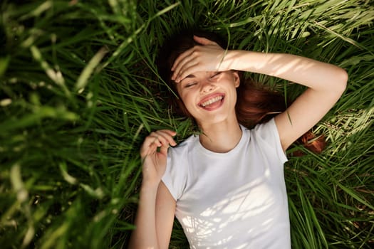 portrait of smiling happy woman with teeth on the grass. High quality photo