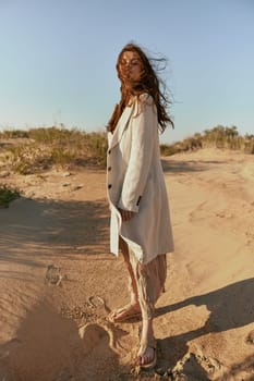 stylishly dressed woman stands posing in the desert in windy weather. High quality photo