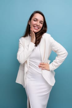 European pretty brunette young woman in a dress and jacket with a grimace.