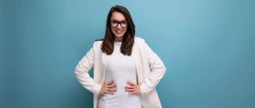 business brunette woman in white office dress on blue studio background.