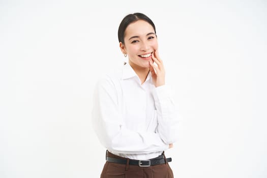 Portrait of smiling korean woman, businesswoman with carefree happiness on her face, white studio background.