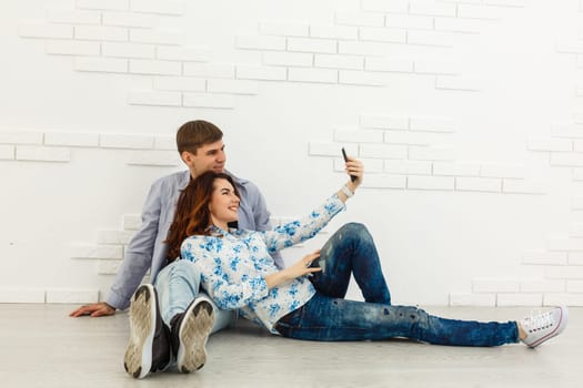 Close up photo of lovely a couple of selfies. They are happy, having fun and taking a selfie, on grey abckground.