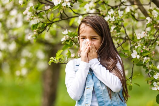 Girl having allergy outdoor, sneezing.