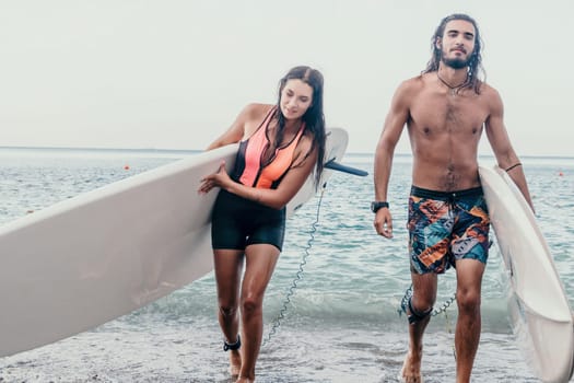 Sea woman and man on sup. Silhouette of happy young woman and man, surfing on SUP board, confident paddling through water surface. Idyllic sunset. Active lifestyle at sea or river