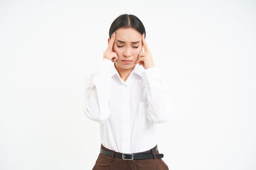 Tired corporate woman, office manager holds hands on head, has headache or migraine, stressed at work, whtie background.