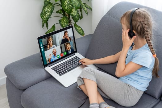 Back view of young girl sit at home talk have online video call lesson with teacher or tutor, teenage schoolgirl engaged in webcam conversation, study distant use web conference app on laptop.