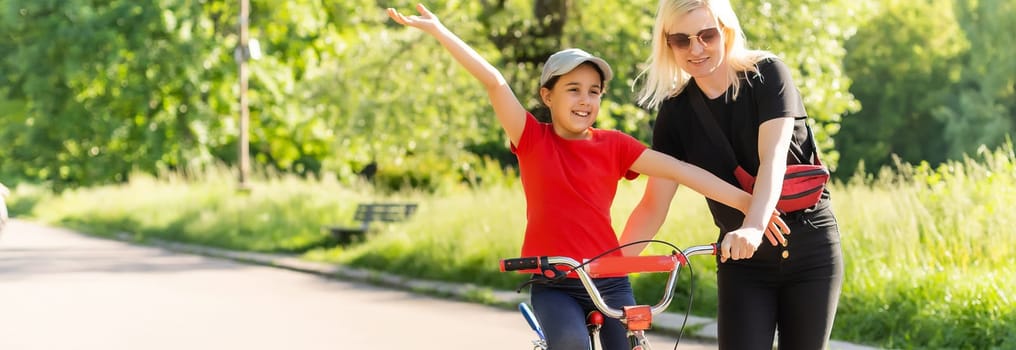 happy little girl with mother practice to riding bicycle.