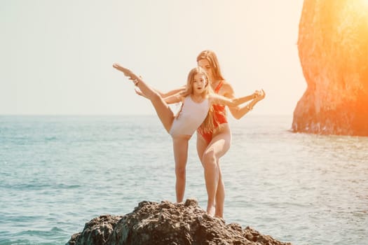 Silhouette mother and daughter doing yoga at beach. Woman on yoga mat in beach meditation, mental health training or mind wellness by ocean, sea