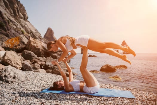 Woman sea yoga. Back view of free calm happy satisfied woman with long hair standing on top rock with yoga position against of sky by the sea. Healthy lifestyle outdoors in nature, fitness concept.