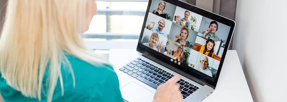 Woman having video chat with colleagues at table in office, closeup.