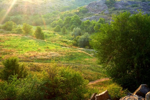 a low area of land between hills or mountains, typically with a river or stream flowing through it.