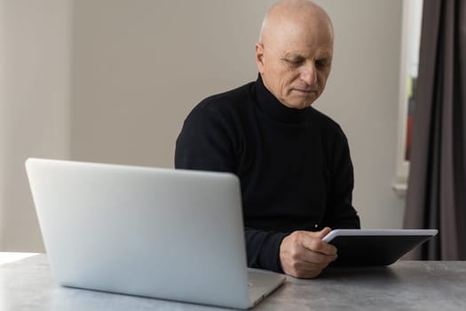 Caucasian old senior stress upset male businessman entrepreneur sitting at working desk having headache after reading graph chart report and contract paperwork document at working desk in office.