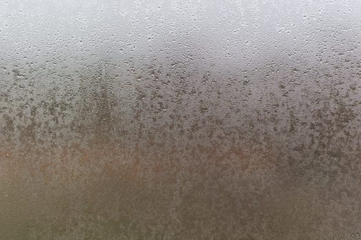 Water droplets condensation background of dew on glass, humidity and foggy blank. Outside, bad weather, rain.