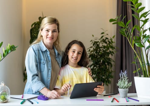 Mother and daughter reading E-book together at home.