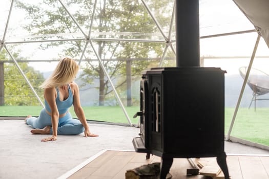 woman doing yoga in glamping dome tent.