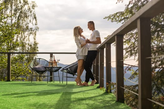 Couple on the balcony against the backdrop of mountains. life terrace pretty happiness summer home