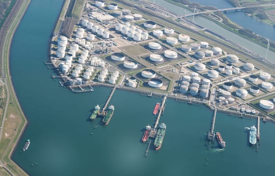 container boats in the europoort harbour at the jetty wit oil storange tanks and the calland canal