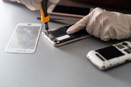 The technician repairing the smartphone's motherboard in the lab with copy space. the concept of computer hardware, mobile phone, electronic, repairing, upgrade and technology