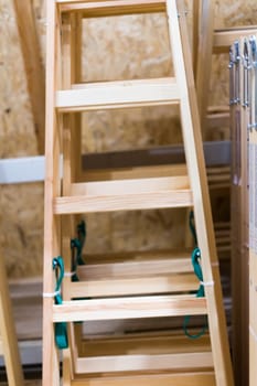 Many Wooden ladders. Stack of wooden stairs in the store.