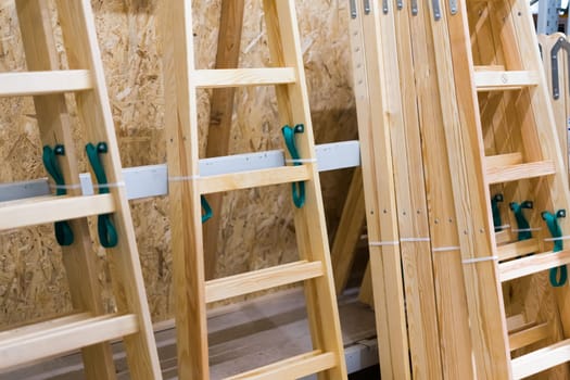 Many Wooden ladders. Stack of wooden stairs in the store.