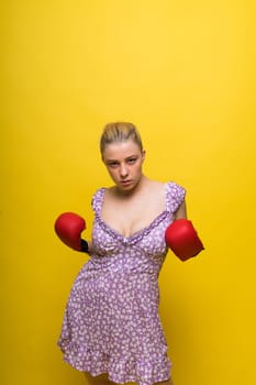 Seductive young and fit female fighter posing in gloves in a studio