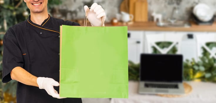 Young handsome man holding delivery paper bag.