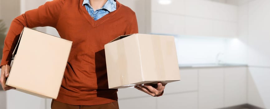 young man carrying three carton boxes.