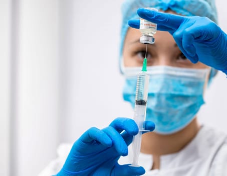 Doctor prepares a syringe with an injection, close-up