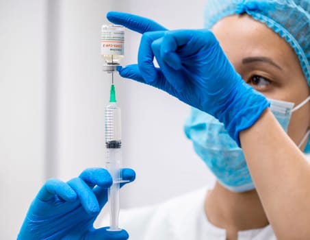 Doctor prepares a syringe with an injection, close-up