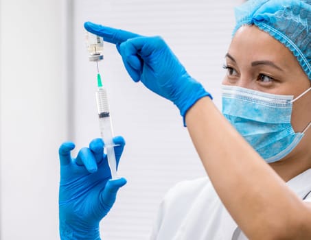 Doctor prepares a syringe with an injection, close-up