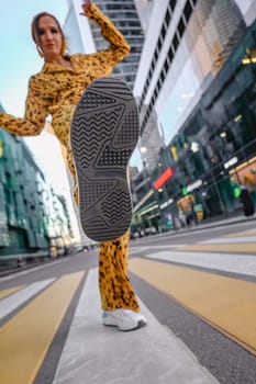 A beautiful shot of a woman in yellow, lifting her heel, and the Moscow City in the background