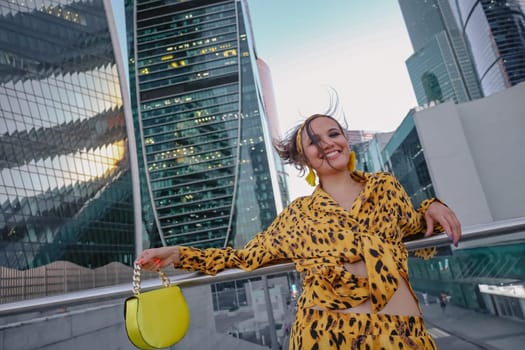 A beautiful shot of woman in yellow smiling and the Moscow City in the background