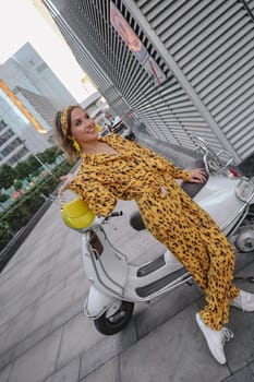 A portrait of a fashion-dressed happy woman posing for a photo shoot on a moped