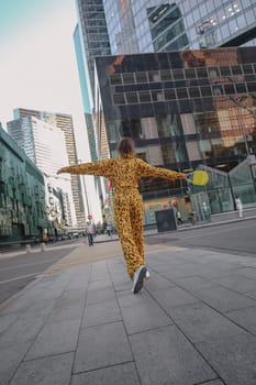 A portrait of a fashion-dressed happy woman posing for a photo shoot on the streets