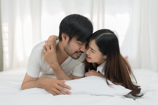 Asian Romantic couple in bed enjoying sensual foreplay Happy sensual young couple lying in bed together. Beautiful loving couple kissing in bed