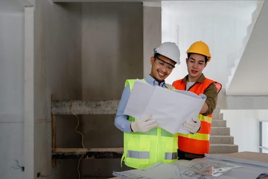 multi ethnic engineer brainstorming and measuring for cost estimating on blueprint and floor plan drawings about design architectural and engineering for houses and buildings.