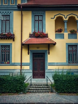 Colorful house facade, vintage style with retro porch and awning. Traditional european building exterior, front view at entrance door