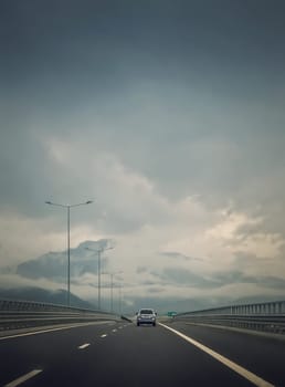 Car moving on the highway in front of a big mountain