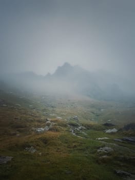 Transfagarasan mountain peak seen through the dense fog. Rainy scene in the mounts, hiking in the mist