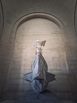 Winged Victory of Samothrace statue in the hall of Louvre museum, Paris, France