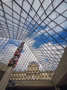 Underneath the Louvre glass pyramid, vertical background. Beautiful architecture details with an abstract mixture of classical and modern styles