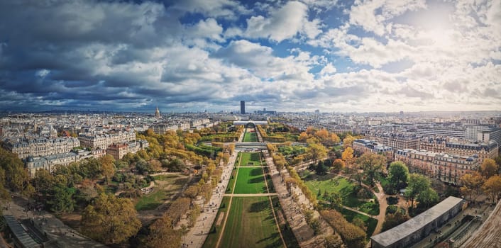 Panoramic view to the Paris cityscape from the Eiffel tower heights, France. Montparnasse tower and Les Invalides seen on the horizon panorama