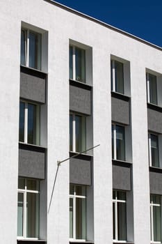 The windows of the white three-story building and the blue sky