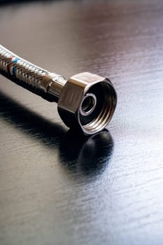 Metal water pipes on a wooden table, copy space