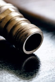 Metal water pipes on a wooden table, macro photo