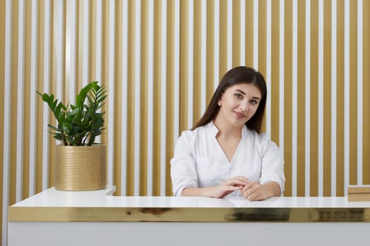 Female receptionist at reception desk in modern office lobby